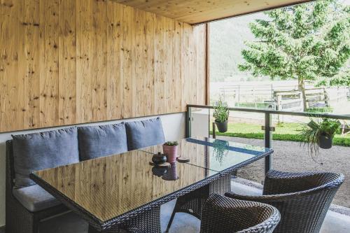a dining room with a glass table and chairs at Ur-Genuss in Heiterwang