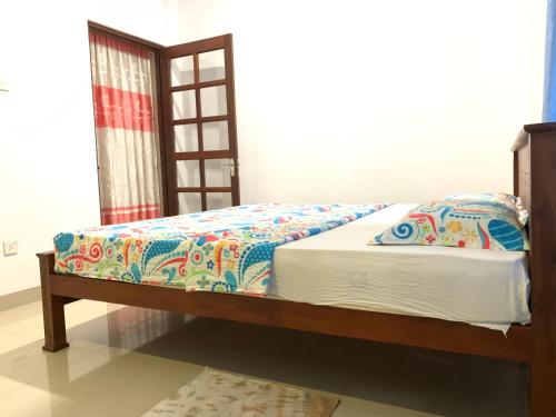a bedroom with a bed with a wooden frame at Mango Villa in Matara