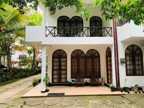 a house with a chair in front of it at Mango Villa in Matara