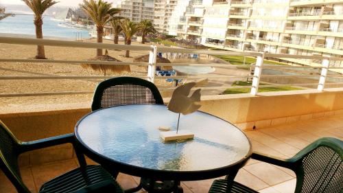 a table and chairs on a balcony with a beach at San Alfonso del Mar Goleta in Algarrobo