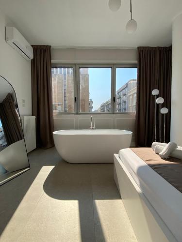 a large bathroom with a tub and a bed at Margherita suites - City center in Bari
