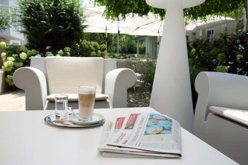 a table with a newspaper and a glass of wine on it at Holiday Inn Vienna City by IHG in Vienna
