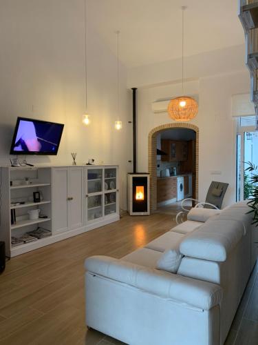 Una sala de estar con un sofá blanco y un televisor. en Un pequeño lujo a pocos metros de la playa, en Piles