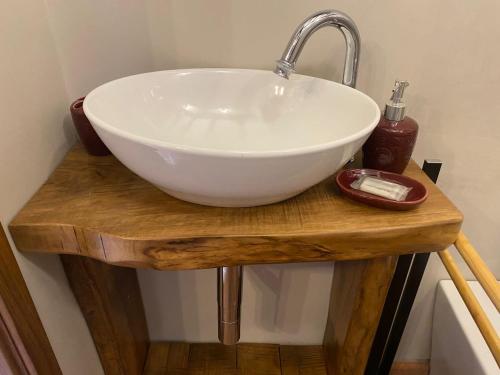 a white bowl sink on a wooden table in a bathroom at La Casina D' Avena in Agna