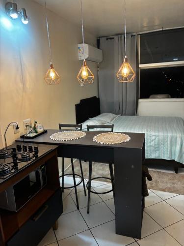 a kitchen with a table and a bed in a room at Flat Aconchegante in Goiânia