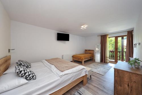 a bedroom with a large bed and a television at Pensiunea Anotimpuri Bran in Bran