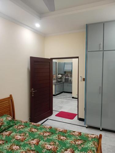 a bedroom with a bed and a door leading to a kitchen at Prime Executive Residence in Rawalpindi