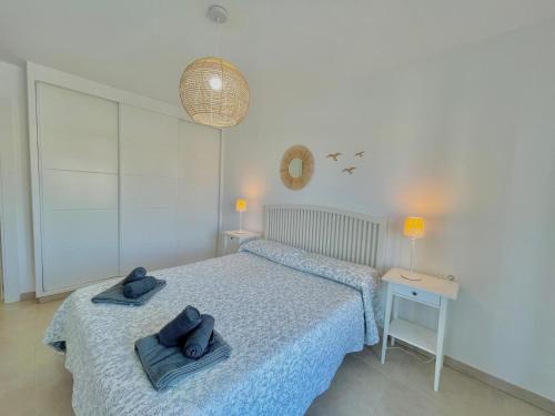 a bedroom with two blue towels on a bed at Terrasol Torre Del Mar Azucarera 4ª Planta in Torre del Mar