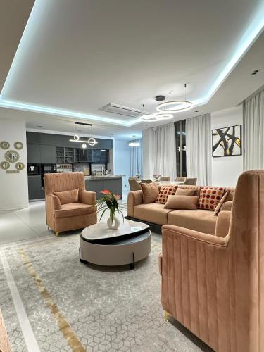 a living room with couches and a table and a kitchen at Platinium résidence in Ngor
