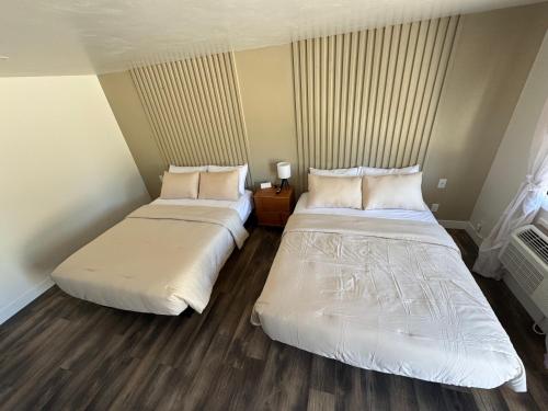 two beds in a hotel room withskirts at Birch Glen Hotel in Cascade