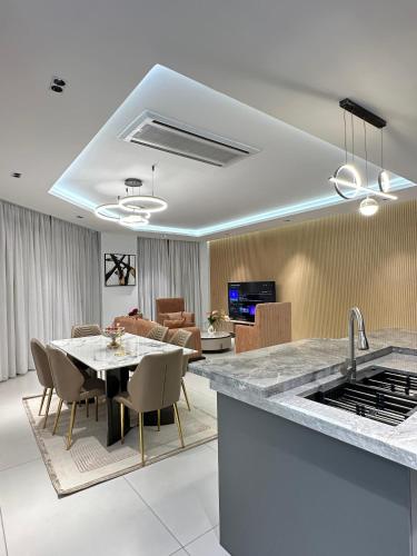 a kitchen and dining room with a table and a kitchen and a living room at Platinium résidence in Ngor