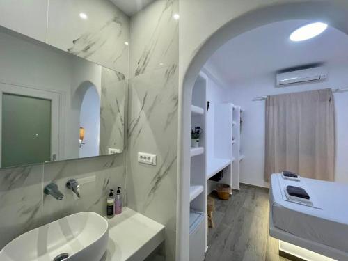 a white bathroom with a sink and a mirror at Alexandra Suites & Rooms - MYKONOS PORT in Mýkonos City
