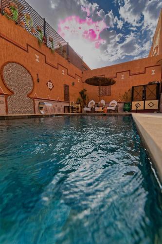 a swimming pool in front of a building at Riad Parfums de OUARZAZATE in Ouarzazate