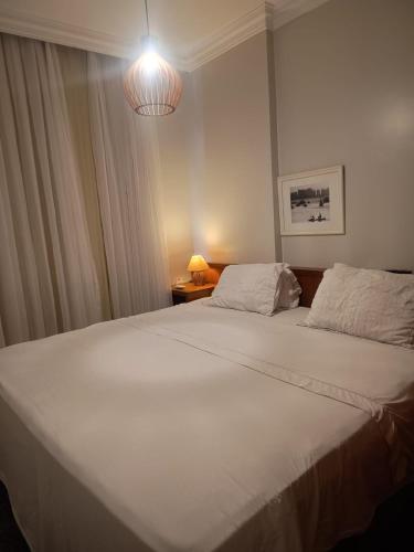 a bedroom with a large white bed and a lamp at Tulip in flat SAN martain in Fortaleza