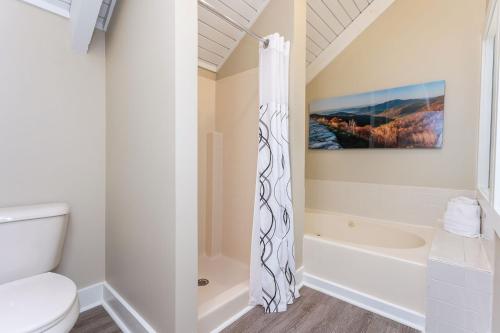 a bathroom with a shower curtain and a toilet at Massanuttens Shenandoah Villas by TripForth in McGaheysville