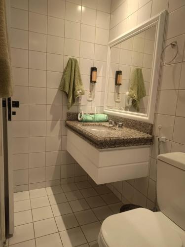 a bathroom with a sink and a mirror and a toilet at Tulip in flat SAN martain in Fortaleza