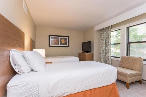 a bedroom with a white bed and a chair at Massanuttens Shenandoah Villas by TripForth in McGaheysville