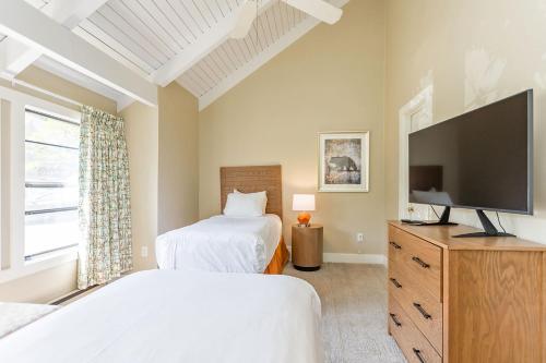 a bedroom with two beds and a flat screen tv at Massanuttens Shenandoah Villas by TripForth in McGaheysville
