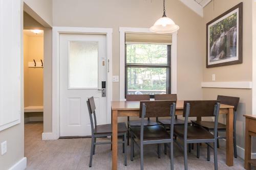 a dining room with a table and chairs and a window at Massanuttens Shenandoah Villas by TripForth in McGaheysville
