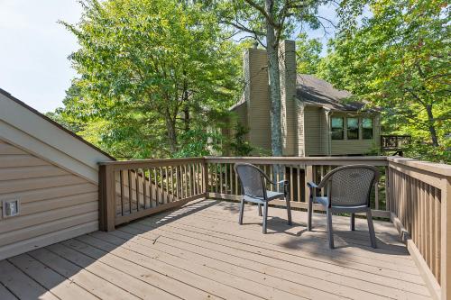 a wooden deck with two chairs and a house at Massanuttens Shenandoah Villas by TripForth in McGaheysville