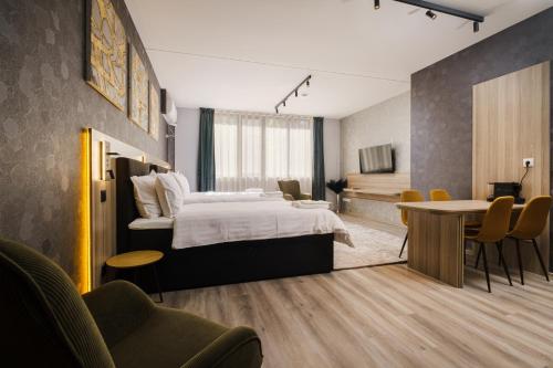 a hotel room with a bed and a table and chairs at А17 Plovdiv Apartments - Next to Rowing Channel and University hospitals in Plovdiv