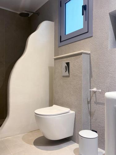 a bathroom with a toilet and a tv on the wall at Rodhéa in Rhodes Town