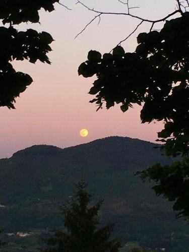 a sunset with the sun rising over the mountains at Hillside semi-detached villa with panoramic views in Schignano