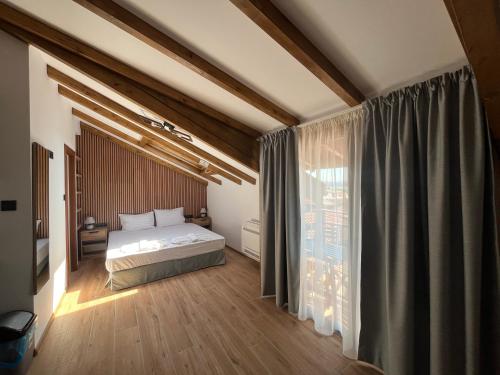 a bedroom with a bed and a large window at Къща за гости Сирената in Sozopol