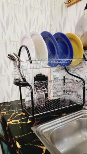 un égouttoir avec des assiettes et des bols sur un évier dans l'établissement Mini Meublé au rez de chaussée, à Dakar