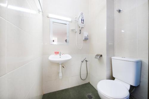 a white bathroom with a toilet and a sink at Midah Inn Puchong in Puchong