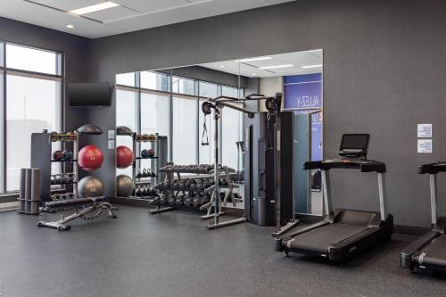 a gym with several tread machines and a mirror at Holiday Inn Express Montreal Airport - St-Laurent by IHG in Montréal
