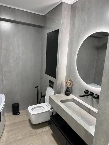 a bathroom with a toilet and a sink and a mirror at Luxury Blue Apartment in Satu Mare