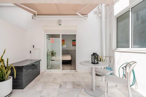 a room with a table and chairs and a desk at Sofia Luxury Apartment in Seville