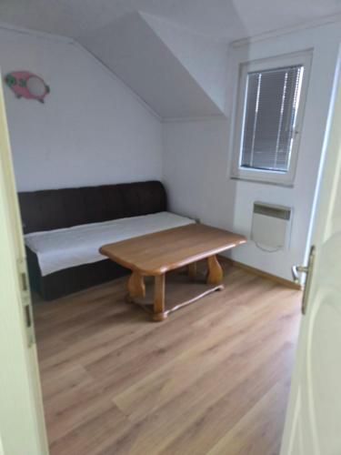 a small room with a bed and a table at Holiday & Living House Near Sarajevo in Vogošća