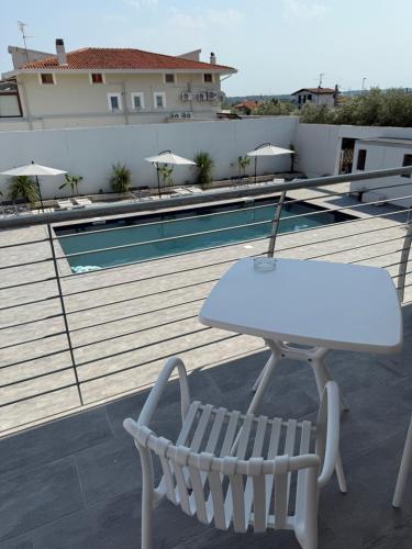 a white table and a chair on a balcony with a pool at Omai suite in Ortona