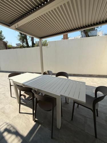a white picnic table and chairs under an umbrella at Omai suite in Ortona