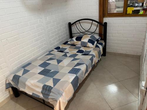 a bed with a blue and white comforter in a room at Casa Refugio natural in Puerto Triunfo