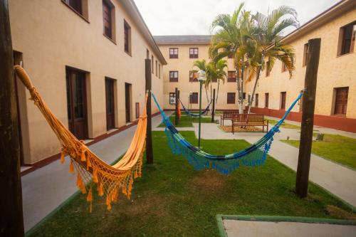 two hammocks on the grass in front of a building at Hotel Nacional Inn Araxá Previdência in Araxá