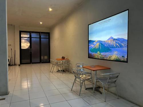 une pièce avec des tables et des chaises et un écran de projection au mur dans l'établissement Pasuruan heritage guest house, 