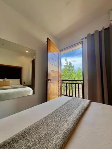 a bedroom with a bed and a balcony at Casa Marga Inn, Panglao in Panglao Island