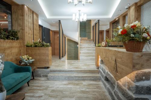 a lobby of a hotel with stairs and flowers at Angelina Apart Hotel&Spa in Divčibare