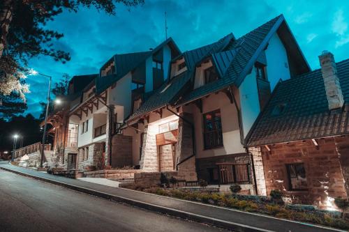 a house with a green roof on a street at Angelina Apart Hotel&Spa in Divčibare