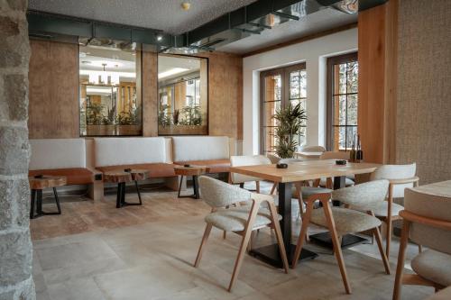 a restaurant with tables and chairs and windows at Angelina Apart Hotel&Spa in Divčibare