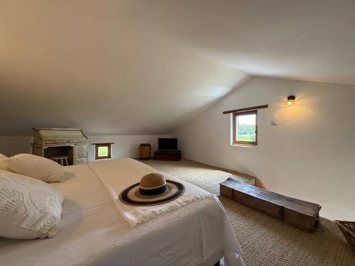 a bedroom with a large bed with a hat on it at Le Clos des Pigières Gîte le Grènetier in Vaison-la-Romaine