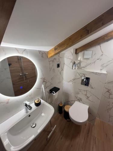 a bathroom with a white sink and a toilet at Къща за гости Сирената in Sozopol