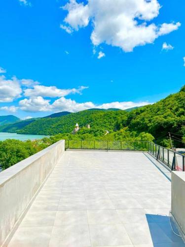a balcony with a view of the water and mountains at Berg Ananuri in Ananuri
