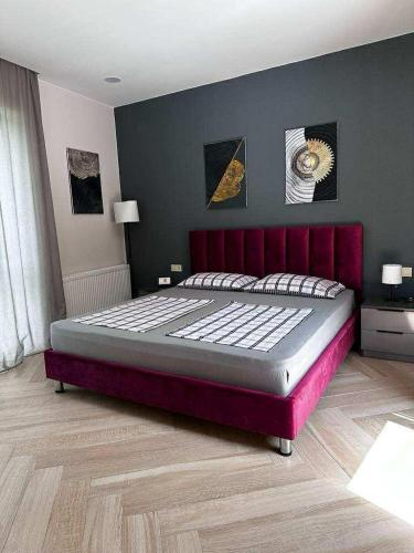 a bedroom with a large bed with a red headboard at Berg Ananuri in Ananuri