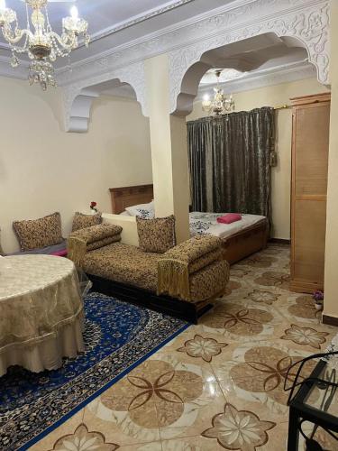 Una sala de estar con dos camas y sillas en una habitación. en Dar RACHIDA RIFIYA Estudio privado, en Tánger