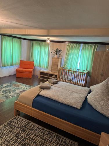 a bedroom with a large bed and a chair at Haus Bernstein Apartment 3 in Haus im Ennstal