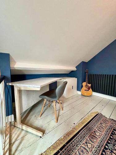 a desk with a chair and a guitar in a room at Central 2br I Pets I Parking in Hereford